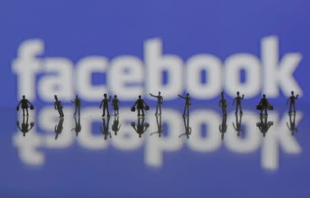 3D-printed models of people are seen in front of a Facebook logo in this photo illustration taken June 9, 2016. REUTERS/Dado Ruvic/Illustration