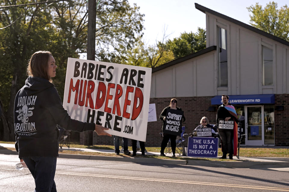 Demonstrators on both sides of the abortion issue stand outside a Planned Parenthood clinic Saturday, Oct. 15, 2022, in Kansas City, Kan. (AP Photo/Charlie Riedel)