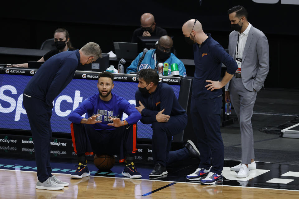 Stephen Curry of the Golden State Warriors speaks with head coach Steve Kerr