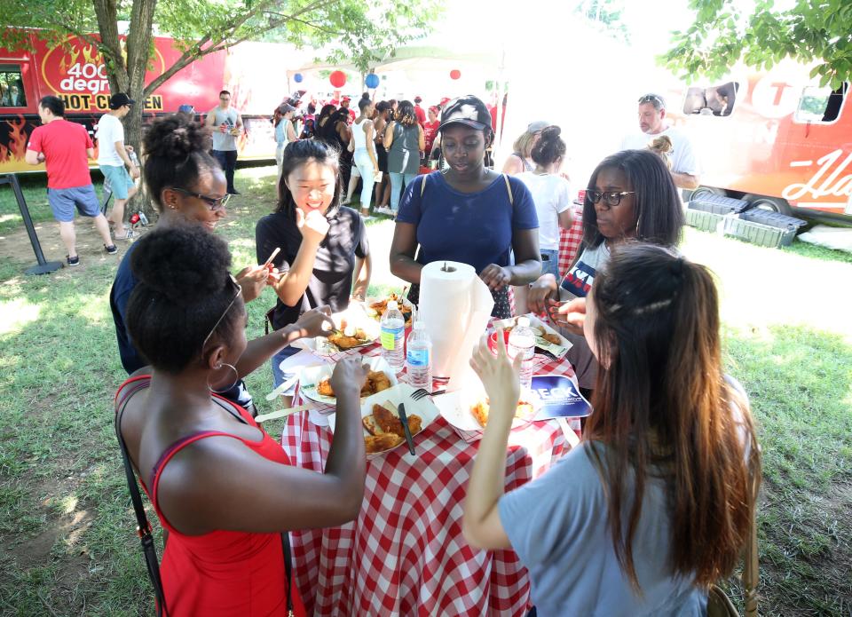 Festivalgoers flock to the shade to enjoy their meals during the Music City Hot Chicken Festival.