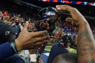 UTSA players are reflected as they reach to touch their championship trophy after an NCAA college football game in the Conference USA Championship against Western Kentucky, Friday, Dec. 3, 2021, in San Antonio. (AP Photo/Eric Gay)