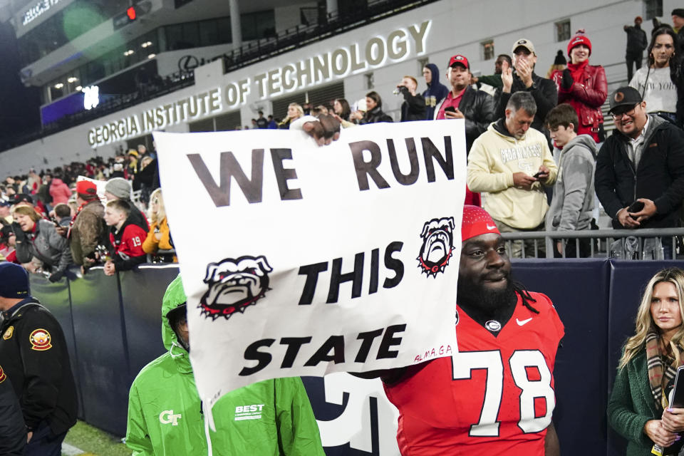 Georgia defensive lineman Nazir Stackhouse (78) carries a sign off the field after defeating Georgia Tech in an NCAA college football game, Saturday, Nov. 25, 2023, in Atlanta. (AP Photo/John Bazemore)
