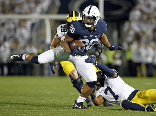 Penn State’s Saquon Barkley (26) makes a move on Michigan’s Khaleke Hudson (7) during the first half of an NCAA college football game in State College, Pa., Saturday, Oct. 21, 2017. (AP Photo/Chris Knight)