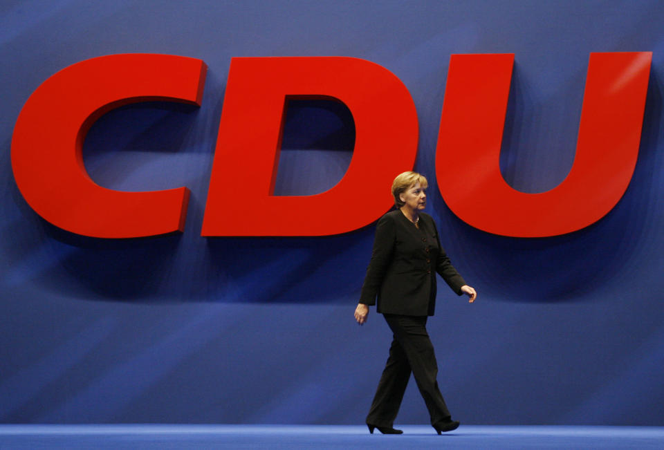 FILE - In this Monday, Dec. 3, 2007 file photo, German Chancellor Angela Merkel walks past a CDU sign during the Christian Democratic Union party congress in Hanover, Germany. Angela Merkel will leave office in the coming months with her popularity intact, despite her party’s dismal election result. (AP Photo/Michael Sohn, File)