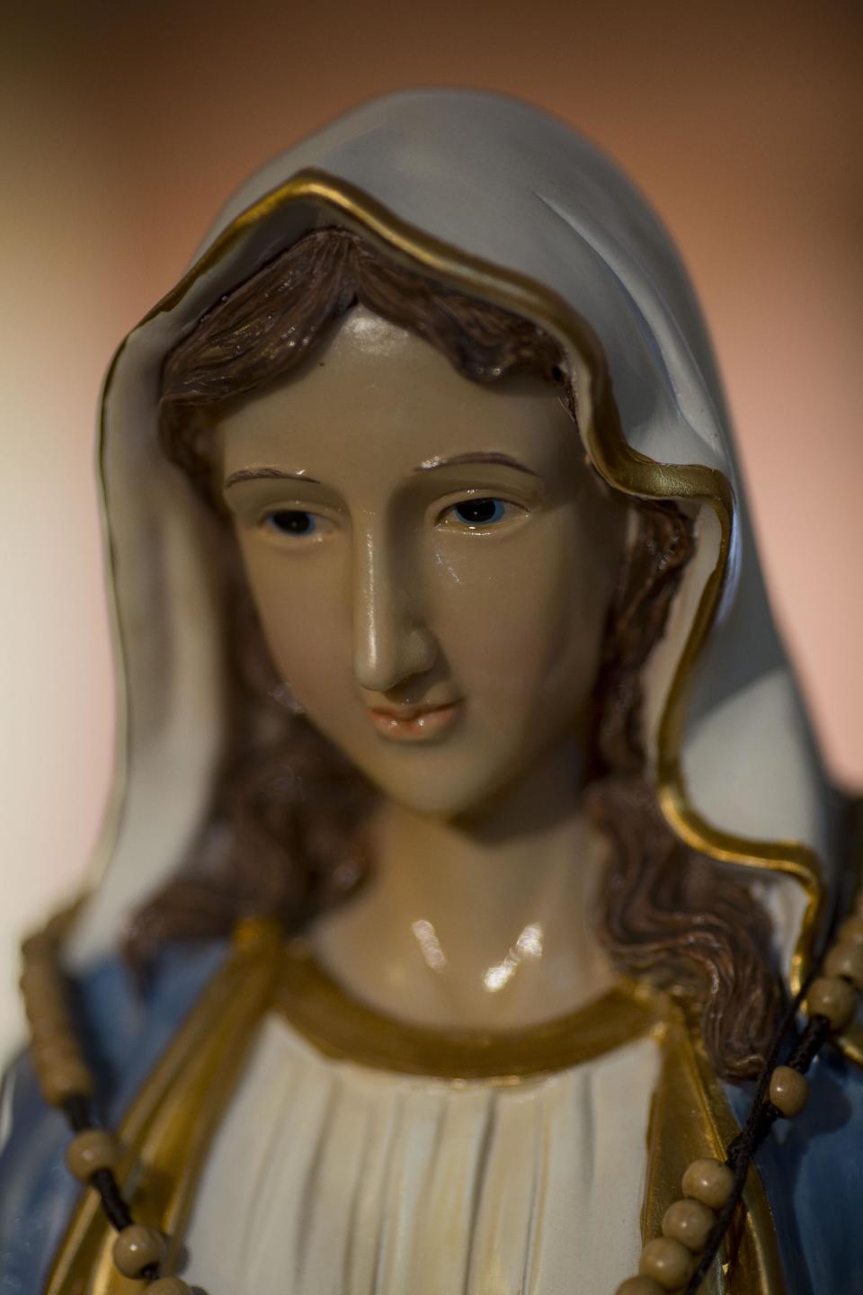 A statue of the Virgin Mary, that residents say "weeps" oil, has attracted thousands of visitors in the last week to an apartment belonging to the Khoury family, in Tarshiha, a small Israeli town near the Lebanon border, Tuesday, Feb. 11, 2014. The family says it is most striking when a "tear" seems to roll down the statue's cheek. Parts of the statue appear to be slick with moisture, even after it is wiped off. (AP Photo/Ariel Schalit)