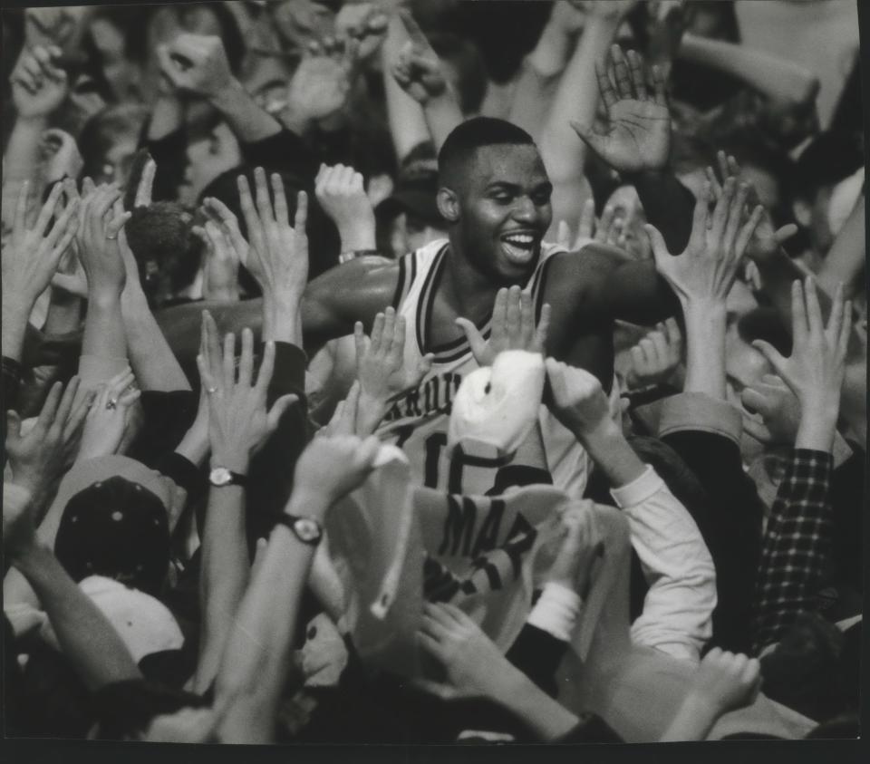 Marquette senior Tony Miller is carried by the Arena crowd after helping his team defeat South Florida, 57-50, in 1995.