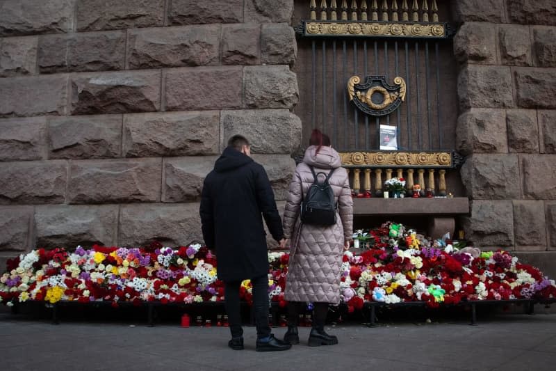 A couple mourns at a make-shift memorial in St. Petersburg's center,  in memory of the victims of the terrorist attack at Crocus City Hall. Artem Priakhin/SOPA Images via ZUMA Press Wire/dpa
