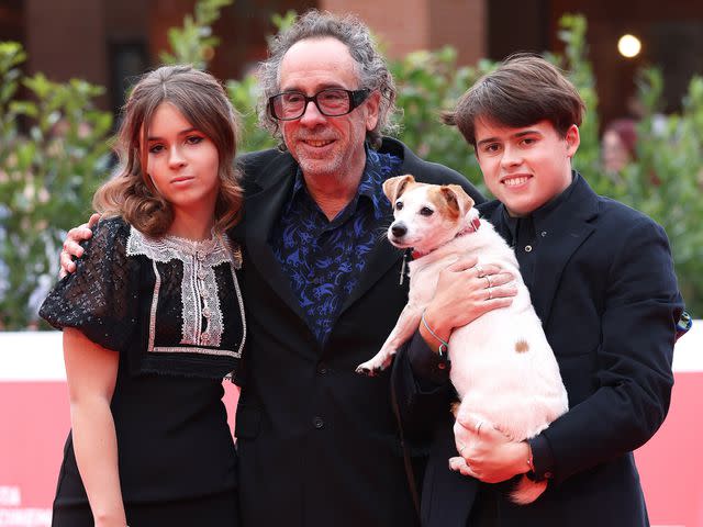 <p>Vittorio Zunino Celotto/Getty</p> Tim Burton with his kids, Billy Raymond Burton and Nell Burton, and Levi the dog attend the Tim Burton Close Encounter red carpet during the 16th Rome Film Fest on October 23, 2021.