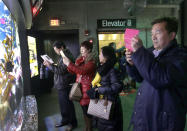 In this March 27, 2017, file photo, tourists from China take pictures at the New England Aquarium in Boston. With tens of millions of Chinese ordered to stay put and many others opting to avoid travel as the new coronavirus spreads, tourism around the global is taking a heavy hit during one of the biggest travel seasons, the Lunar New Year. (AP Photo/Elise Amendola, File)