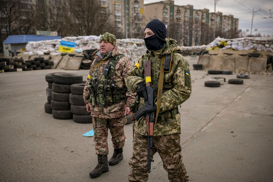 A Ukrainian serviceman has "Mommy" written on his weapon strap as he stands guard at a checkpoint on a main road in Kyiv, Ukraine.