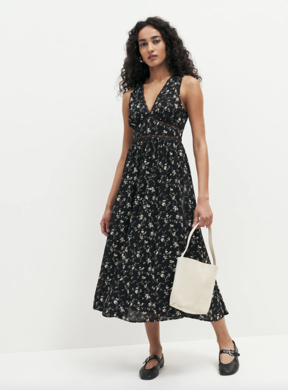 model wearing black flats and black floral midi dress, Zaid Dress (photo via Reformation)