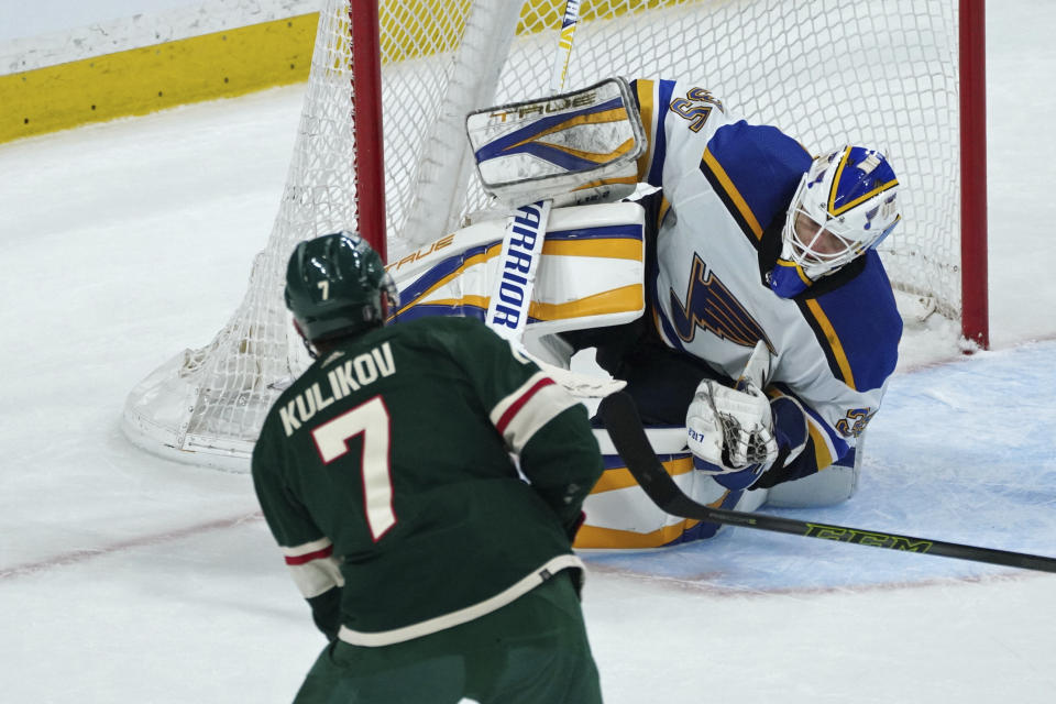 St. Louis Blues goalie Ville Husso, right, makes a diving save on a shot by Minnesota Wild's Dmitry Kulikov (7) in the third period of Game 1 of an NHL hockey Stanley Cup first-round playoff series, Monday, May 2, 2022, in St. Paul, Minn. The Blues won 4-0. (AP Photo/Jim Mone)