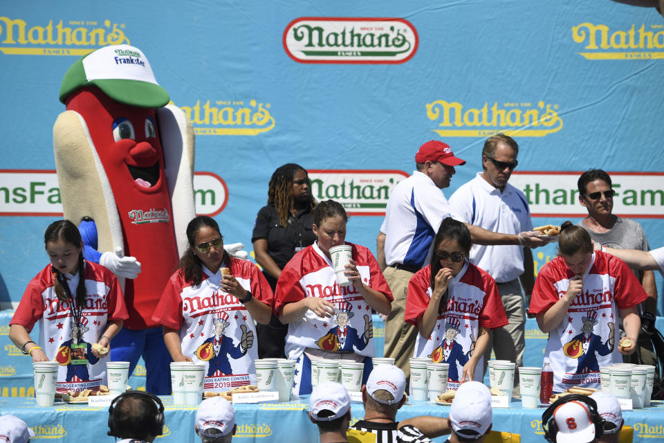 Competitors consume hot dogs during the women's competition of Nathan's Famous July Fourth hot dog eating contest, Thursday, July 4, 2019, in New York's Coney Island. (AP Photo/Sarah Stier)