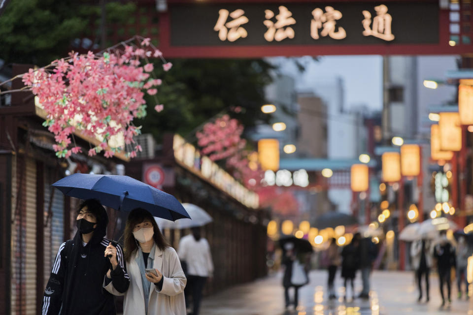 People walk through a shopping street along the famed Sensoji temple in the Asakusa neighborhood in Tokyo on Thursday, April 29, 2021. Most stores were temporarily closed due to the coronavirus state of emergency according to signs on the storefronts. (AP Photo/Hiro Komae)