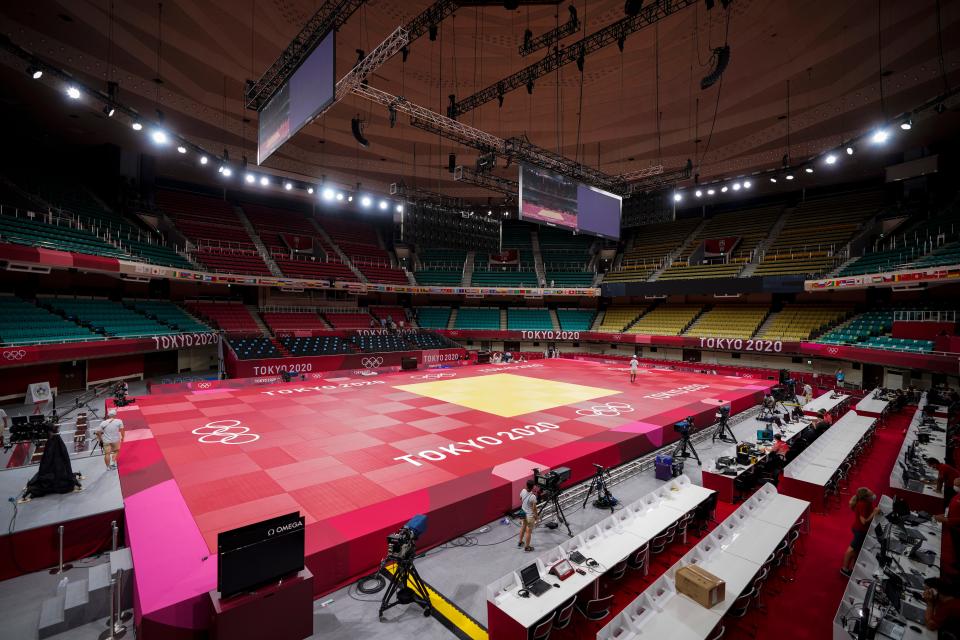 People prepare the field of play for judo at the Nippon Budokan ahead of the 2020 Summer Olympics, Friday, July 23, 2021, in Tokyo, Japan.