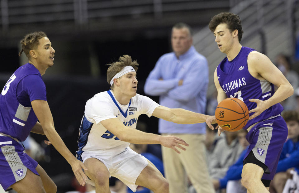 Creighton's Baylor Scheierman, center, tips the ball away from St. Thomas' Will Engels, right, while under pressure from Ahjany Lee during the first half of an NCAA college basketball game on Monday, Nov. 7, 2022, in Omaha, Neb. (AP Photo/Rebecca S. Gratz)