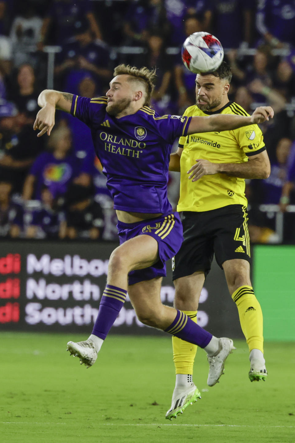 Columbus Crew defender Rudy Camacho, right, heads the ball with Orlando City midfielder Dagur Dan Þorhallsson, left, defending during the first half of an MLS soccer playoff match, Saturday, Nov. 25, 2023, in Orlando, Fla. (AP Photo/Kevin Kolczynski)