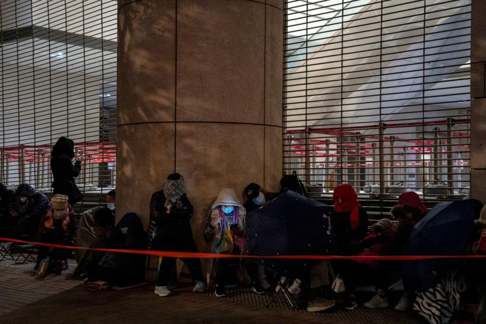 People wait behind a police line set up outside West Kowloon Magistrates' Courts (Copyright 2023 The Associated Press. All rights reserved.)