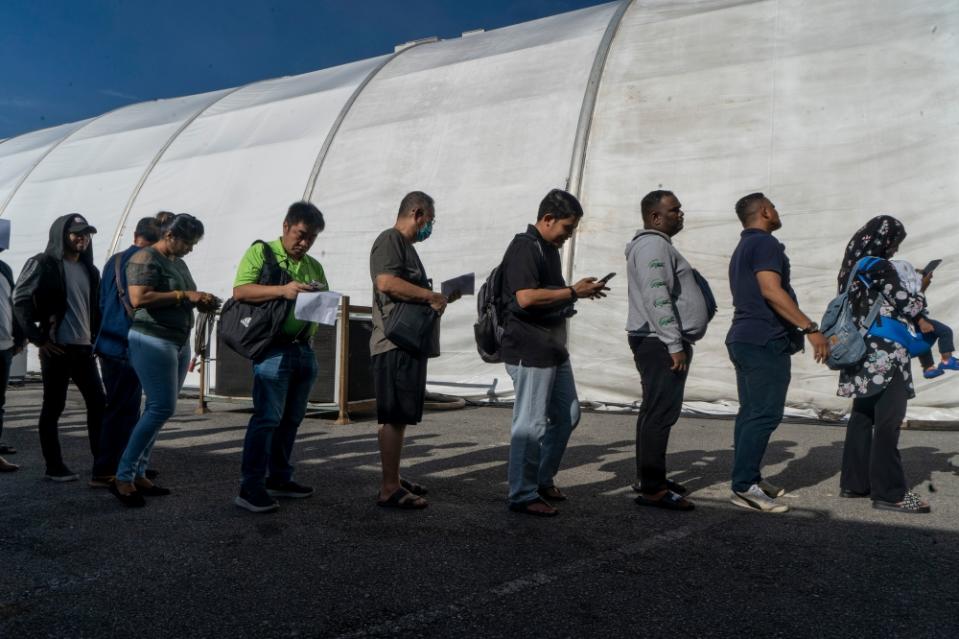 Visitors stand in line to pay their traffic summonses with the offer of discounts of up to 50 per cent by Royal Malaysia Police during the Madani Government One Year Anniversary Programme at the Bukit Jalil National Stadium December 9, 2023. — Picture by Shafwan Zaidon