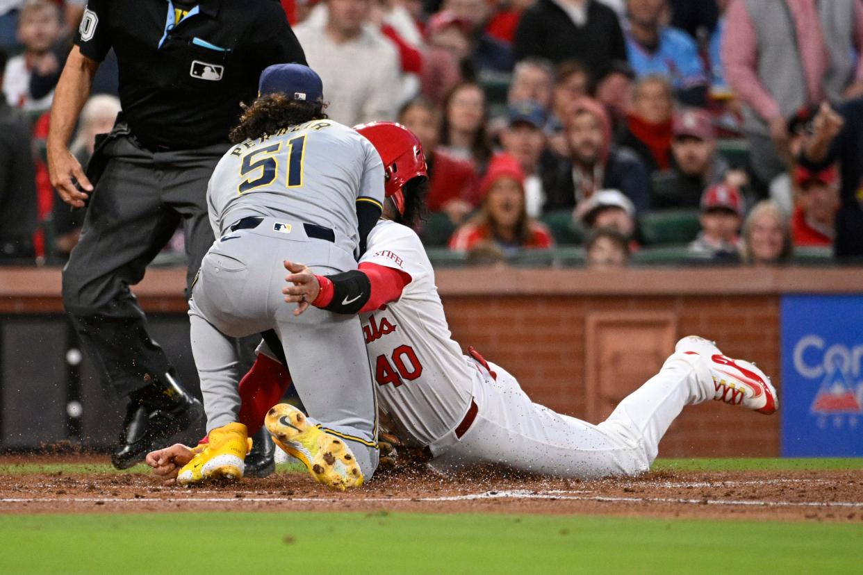 St. Louis Cardinals catcher Willson Contreras slides into home plate and is tagged out by Milwaukee Brewers pitcher Freddy Peralta in the second inning Friday night at Busch Stadium.
