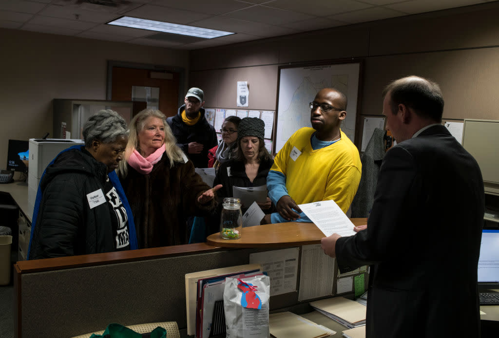 Alongside other protestors, Gladyes Williamson, of Flint, Michigan, delivers a list of demands, including a demand to keep water distribution sites open, to the offices of state representatives on April 11, 2018 in Lansing, Michigan. (Photo by Brittany Greeson/Getty Images)