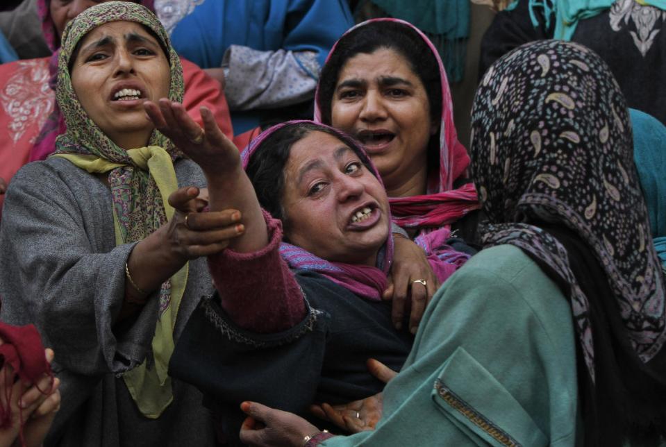 Unidentified women try to comfort a wailing relative, center, of Ghulam Nabi, a rural body head of a pro-Indian party, during a joint funeral procession of Ghulam and his son Firdous Ahmad at Batgund village, some 40 kilometers (25 miles) south of Srinagar, India, Tuesday, April 22, 2013. Police say suspected rebels have killed three men in Indian Kashmir ahead of voting in general elections this week.More than a dozen rebel groups have been fighting for Kashmir's independence from India or merger with Pakistan since 1989. (AP Photo/Mukhtar Khan)