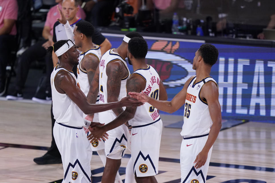 Denver Nuggets players celebrate the team's win over the Los Angeles Clippers in an NBA conference semifinal playoff basketball game Tuesday, Sept. 15, 2020, in Lake Buena Vista, Fla. (AP Photo/Mark J. Terrill)