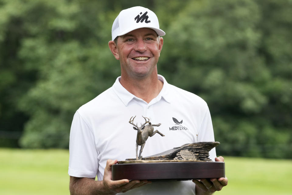 Lucas Glover holds the trophy after winning the John Deere Classic golf tournament, Sunday, July 11, 2021, at TPC Deere Run in Silvis, Ill. (AP Photo/Charlie Neibergall)