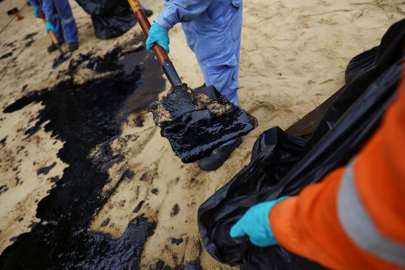 Workers clean up the oil slick at Tanjong Beach in Sentosa