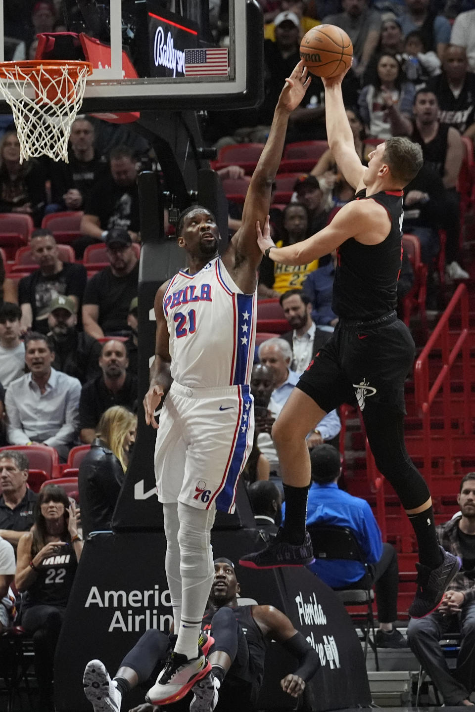 Miami Heat forward Nikola Jovic (5) drives to the basket as Philadelphia 76ers center Joel Embiid (21) defends during the first half of an NBA basketball game, Thursday, April 4, 2024, in Miami. (AP Photo/Marta Lavandier)