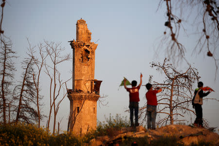 Boys play near the 14th century Tawashi Mosque with a damaged minaret, in the old city of Aleppo, Syria April 12, 2019. Picture taken April 12, 2019. REUTERS/Omar Sanadiki TPX IMAGES OF THE DAY