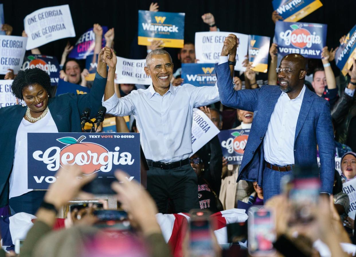 Former President Barack Obama raises hands with Stacey Abrams and U.S. Sen. Raphael Warnock at a Oct. 28, 2022, campaign event in Georgia. <a href="https://www.gettyimages.com/detail/news-photo/former-president-barack-obama-raises-hands-with-democratic-news-photo/1244303190?phrase=raphael%20warnock&adppopup=true" rel="nofollow noopener" target="_blank" data-ylk="slk:Elijah Nouvelage/Getty Images;elm:context_link;itc:0;sec:content-canvas" class="link ">Elijah Nouvelage/Getty Images</a>