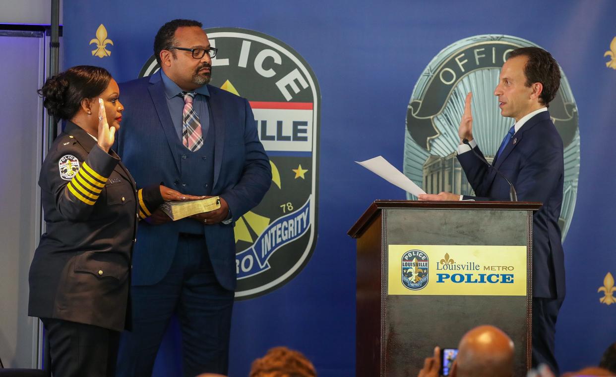 LMPD Chief Jacquelyn Gwinn-Villaroel is sworn in by mayor Craig Greenberg.  Guinn-Villaroel’s husband, David holds a family bible on Friday, August 25, 2023, at the Muhammad Ali Center.