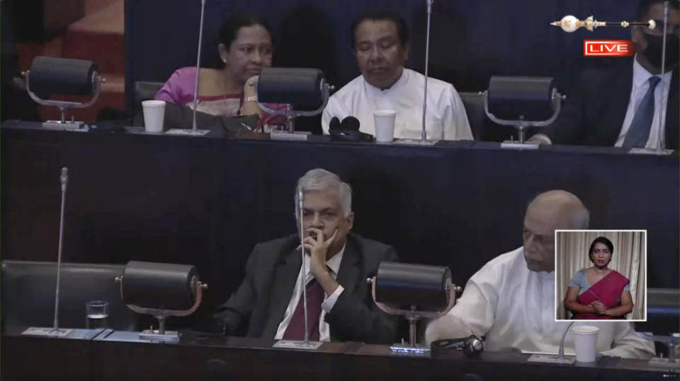 This frame grab from video taken from the official YouTube channel of the Parliament of Sri Lanka shows Acting President and Prime Minister Ranil Wickremesinghe, center, as lawmakers elect a new president in Colombo, Sri Lanka, Wednesday, July 20, 2022. Wickremesinghe was elected president Wednesday, in a secret parliamentary ballot that risked reigniting turmoil among a public outraged by the South Asian nation's economic collapse. (Parliament of Sri Lanka via AP)