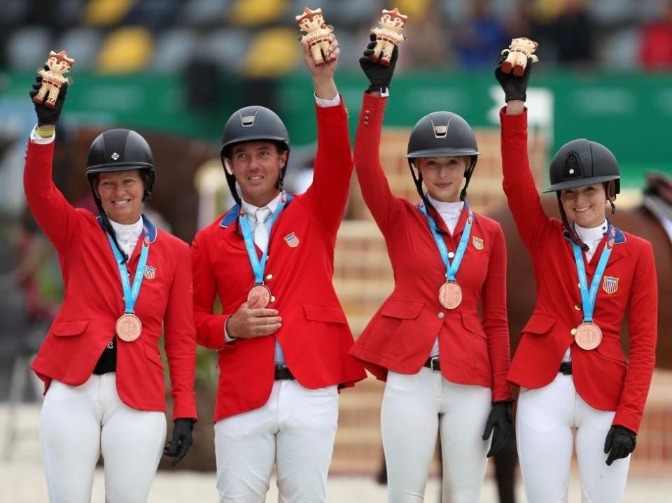 US' team (L to R) Elizabeth Madden, Alex Granato, Eve Jobs, the daughter of the late co-founder and CEO of Apple Inc. Steve Jobs, and Lucy Deslauriers celebrate their bronze in the Equestrian Jumping Team Round 2 competition, during the Lima 2019 Pan-American Games in Lima on August 7, 2019.