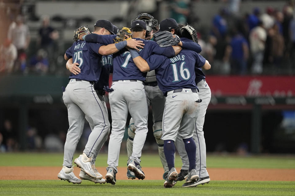 Seattle Mariners' Dylan Moore (25), Jorge Polanco (7), Luis Urias (16) and others celebrate after the team's 4-3 win in a baseball game against the Texas Rangers in Arlington, Texas, Thursday, April 25, 2024. (AP Photo/Tony Gutierrez)