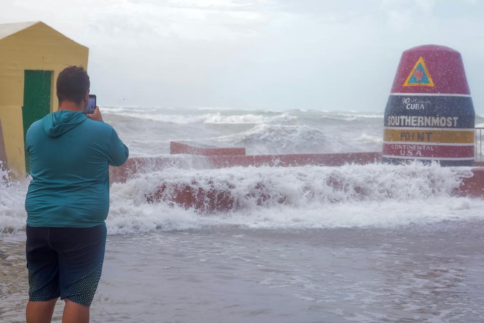 A man braves storm conditions to take photos at the 'Southernmost Point' buoy in Key West on Thursday (EPA/SCOTT HALLERAN)