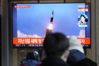 People watch a TV screen showing a news program reporting about North Korea's missile launch with a file image, at a train station in Seoul, South Korea, Thursday, Jan. 27, 2022. North Korea on Thursday fired at least two suspected ballistic missiles into the sea in its sixth round of weapons launches this month, South Korea's military said. (AP Photo/Lee Jin-man)