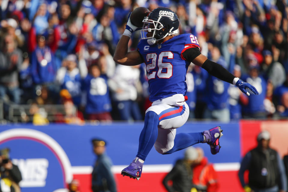 New York Giants' Saquon Barkley leaps into the end zone during the first half of an NFL football game against the Washington Commanders, Sunday, Dec. 4, 2022, in East Rutherford, N.J. (AP Photo/John Munson)