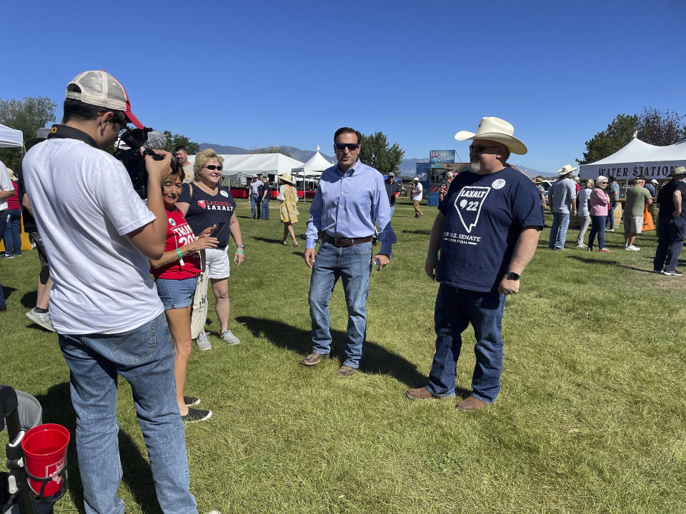 Republican Nevada Senate candidate Adam Laxalt, center, greets supporters at the seventh annual Basque Fry at the Corley Ranch on Saturday, Aug. 13, 2022, outside Gardnerville, Nev. (AP Photo/Gabe Stern)