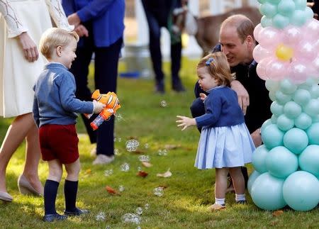 Britain's Prince William and Princess Charlotte look on as Prince George plays with a bubble gun at a children's party at Government House in Victoria, British Columbia, Canada, September 29, 2016. REUTERS/Chris Wattie