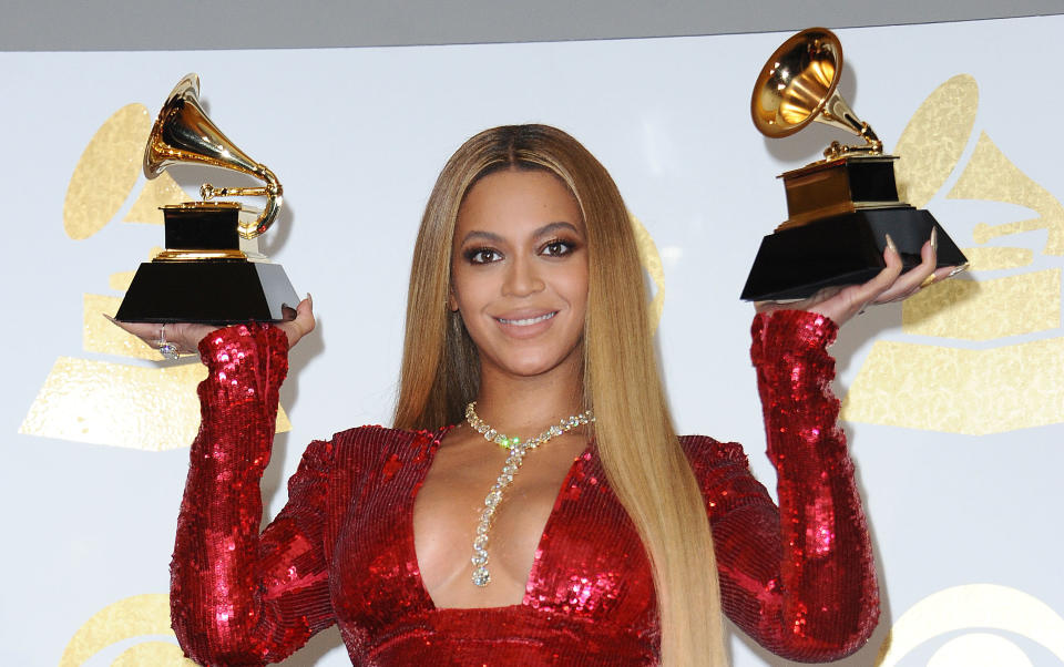 Beyoncé holding up two Grammy Awards