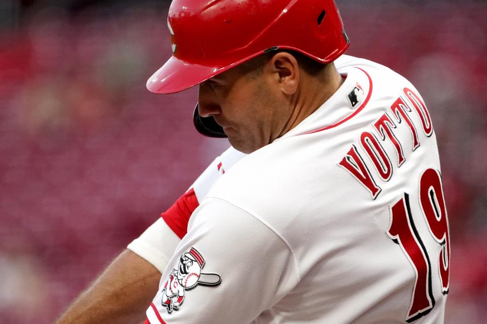 Cincinnati Reds first baseman Joey Votto (19) looks down as he makes contact on a pitch in the third inning during a baseball game against the St. Louis Cardinals, Friday, April 22, 2022, at Great American Ball Park in Cincinnati. 