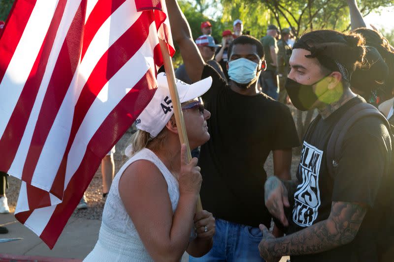 Black Lives Matter protesters interact with demonstrators against restrictions to prevent the spread of the coronavirus disease (COVID-19) in Phoenix