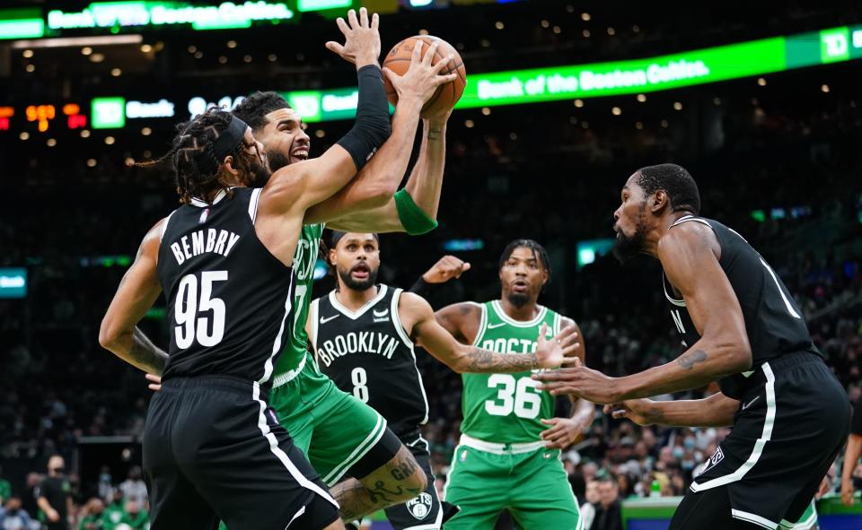 Nov 24, 2021; Boston, Massachusetts, USA; Boston Celtics forward Jayson Tatum (0) drives the ball against Brooklyn Nets forward Bruce Brown (1) and guard DeAndre' Bembry (95) in the second half at TD Garden.