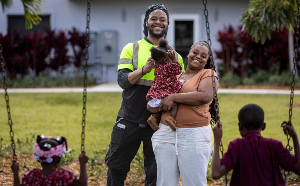 Breon Williams and Darneisha Barnes hold their 10-month-old daughter Da’ Nayvia Barnes as children Da’ Nasia Williams and Rondell Dyer play on the swings at Cloverleaf Park in Miami Gardens on Nov. 20, 2023.