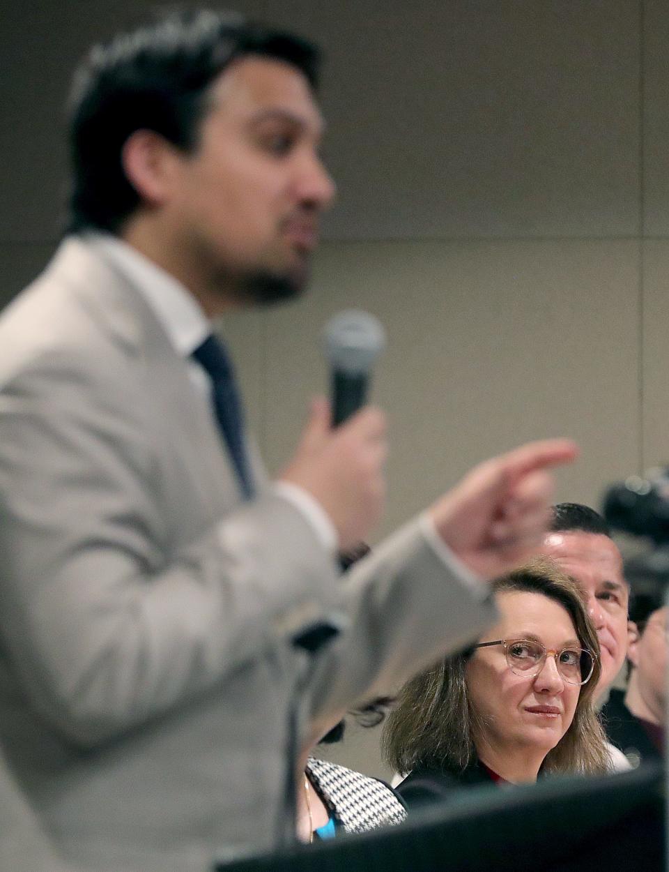 Nanette Pitt, chief of strategy for the city of Akron, listens as Mayor Shammas Malik talks to members of the media Jan. 25 at the Ocasek Auditorium.