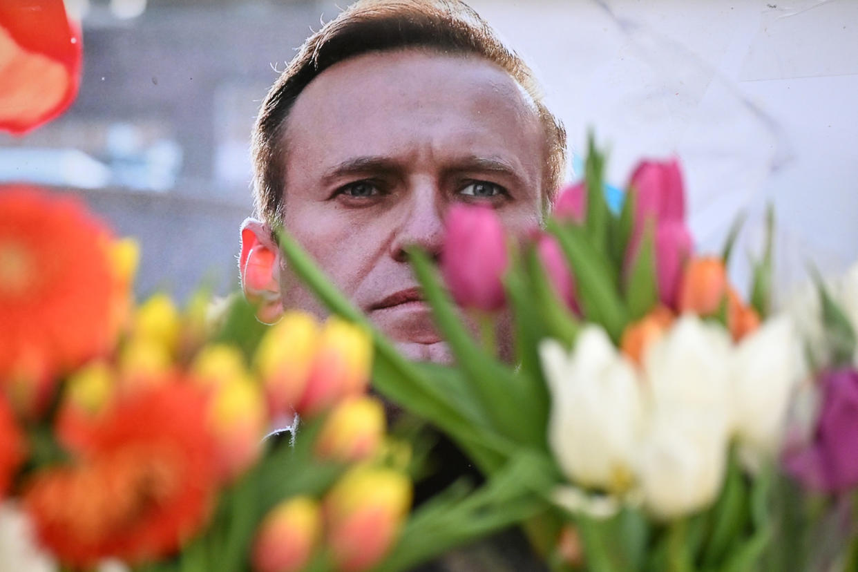 Flowers are seen placed around portraits of Alexei Navalny at a makeshift memorial in Frankfurt, Germany.