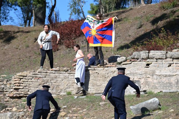 Protesters holding the Tibetan flag crash the flame lighting ceremony for the Beijing 2022 Winter Olympics at the Ancient Olympia archeological site, birthplace of the ancient Olympics in southern Greece on October 18, 2021. - The Olympic flame will once again be lit in an empty stadium on Ovtober 18, 2021, as it starts its truncated journey to Beijing for the Winter Games in February. Like the ceremony in March 2020 to light the flame for Tokyo, and like those Games, which were put back a year, Monday's ceremony is a victim of coronavirus restrictions. (Photo by ARIS MESSINIS / AFP) (Photo by ARIS MESSINIS/AFP via Getty Images) (Photo: ARIS MESSINIS via Getty Images)