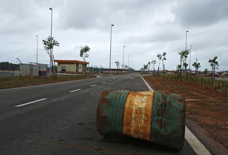 A rusty oil barrel lies in the middle of a road in the largely empty new township built for workers of the Pengerang Integrated Petroleum Complex in Pengerang, in the southeastern tip of Johor, February 4, 2015. REUTERS/Edgar Su